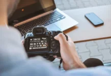 Fotograf mit Kamera und Laptop