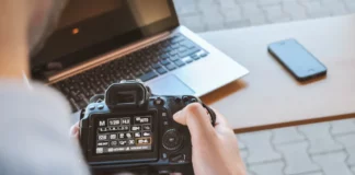 Fotograf mit Kamera und Laptop